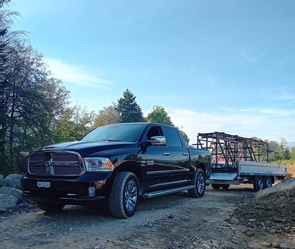 Ein schwarzer SUV PickUp mit Anhänger vom Lieferdienst des Unternehmens HD Oberflächen GmbH